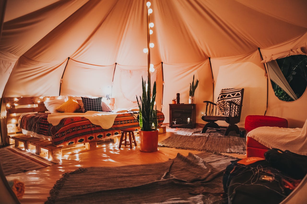 services-01 Luxurious and cozy glamping tent interior with soft lighting, stylish decor, and plants, perfect for relaxation.
