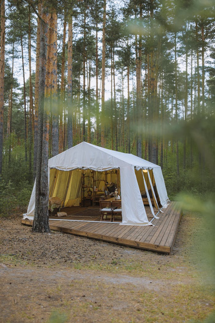 about-us-02 Cozy glamping tent nestled in a serene forest setting on a wooden deck, perfect for a peaceful getaway.